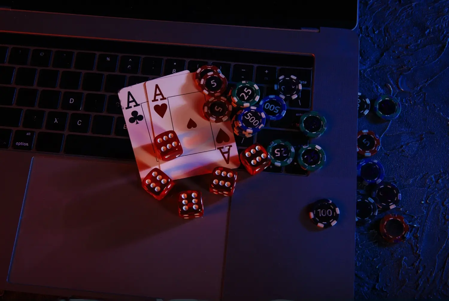 A picture of a laptop, dice and cards